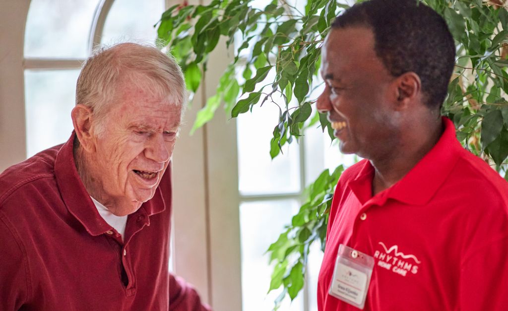 Home care client and care partner smiling and talking