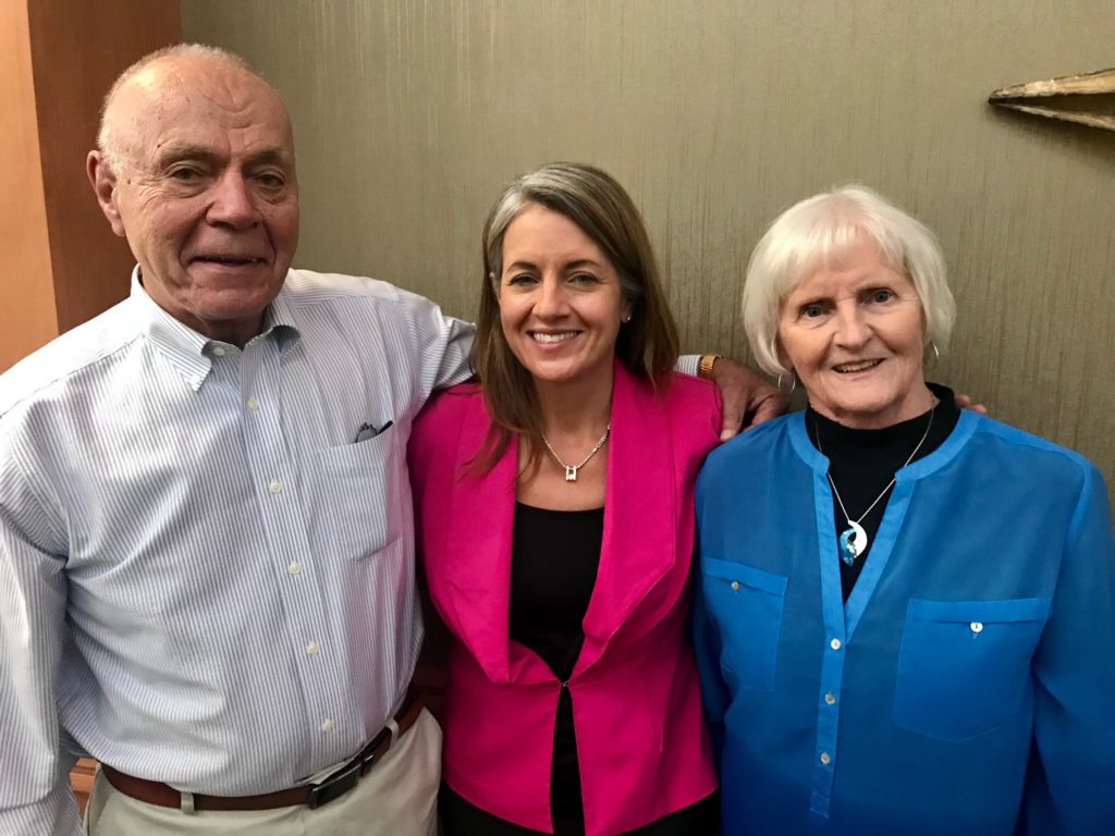 Man and two woman pose together for photo.