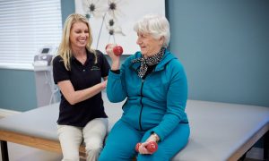 Resident lifts weights during physical therapy session