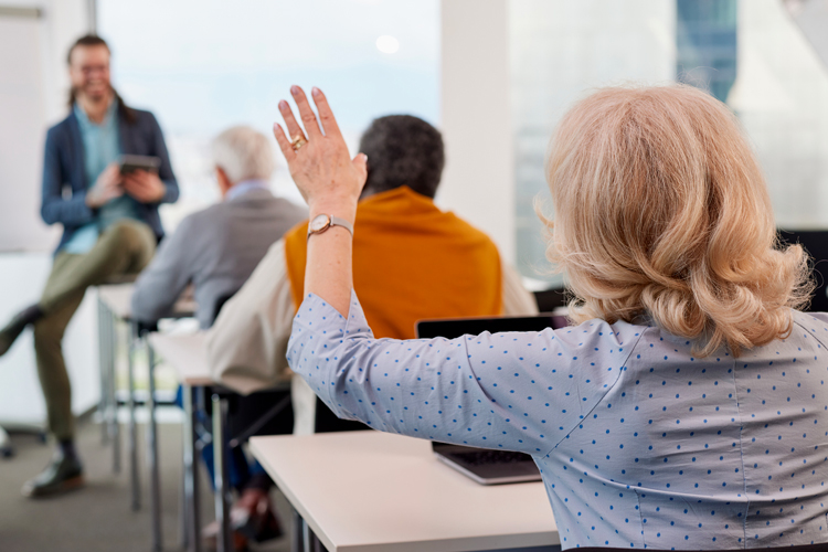 older woman asking question during seminar