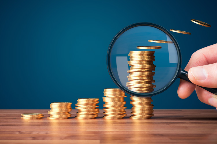 cdms magnifying glass focused on stack of coins cdms magnifying glass focused on stack of coins